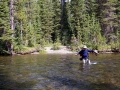 Backpacker crossing the Bechler River